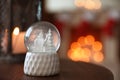 Snow globe on wooden table against background, space for text. Bokeh effect Royalty Free Stock Photo
