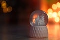 Snow globe on wooden table against blurred background. Bokeh effect Royalty Free Stock Photo