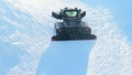 Snow groomer, piste basher cleaning skiing run, winter Olympics