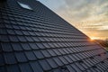 Snow guard for safety in winter on house roof top covered with steel shingles. Tiled covering of building Royalty Free Stock Photo