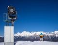 Snow Gun and snowboarder woman in mountains