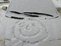 Snow happy face on the car window. Smile in the snow, happy cheerful image. Royalty Free Stock Photo