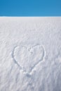 Snow heap with carved love heart, blue sky
