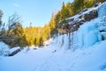 Snow and ice blue frozen waterfall on cliffs during sunset Royalty Free Stock Photo