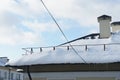 Snow and ice on the roofs of buildings. Icicles hang from the roofs of houses. The probability of the roof collapsing under the