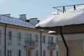 Snow and ice on the roofs of buildings. Icicles hang from the roofs of houses. The probability of the roof collapsing under the