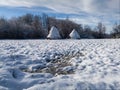 Snow idyll, winter landscape, two haystacks on the meadow covered with snow during a sunny day Royalty Free Stock Photo