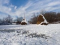 Snow idyll, winter landscape, two haystacks on the meadow covered with snow during a sunny day Royalty Free Stock Photo