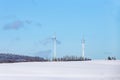 snow landscape in the Harz mountains with blue sky and trees and wind generator Royalty Free Stock Photo