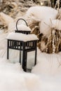 Snow on the lantern in the grass garden.