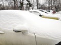 Snow layer on windscreen, window of sedan in city street driveway parking lot spot. car stuck after heavy blizzard Royalty Free Stock Photo