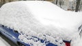 Snow layer on windscreen, window of sedan in city street driveway parking lot spot. car stuck after heavy blizzard Royalty Free Stock Photo
