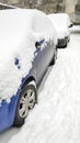 Snow layer on windscreen, window of sedan in city street driveway parking lot spot. car stuck after heavy blizzard Royalty Free Stock Photo