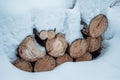 Snow log stack lumber in winter. Woodpile of pine