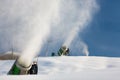 Snow-machine bursting artificial snow over a skiing slope