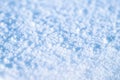 Snow with melted ice crystals and soft blue shadows on a sunny winter day. Background. Selective focus Royalty Free Stock Photo