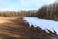 Snow melting on a plowed field in early spring. Fertile black soil Royalty Free Stock Photo