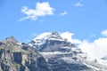 The snow mountain rises high under the blue sky Royalty Free Stock Photo