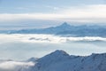 Snow mountains in backlight, bright sunny day winter on the Alps, high snowcapped mountain peaks, fog and clouds in the valleys be