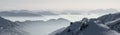 Snow Mountains Panorama in low lying inversion valley fog. Silhouettes of foggy Mountains. Scenic snowy winter landscape Royalty Free Stock Photo