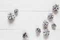Snow painted pine cones on rustic white wood table. Space for te