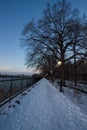 Snow pathway next to lake with sunset sky