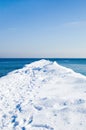 Snow pier in the sea on a sunny winter day