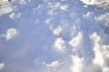 Snow pile on the ground on a sunny winter day. Cold soft snow in the sun, the parts in shade appear blue. Some footprints on the