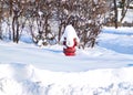 Snow is piled on top of red fire hydrant after winter storm in February. Royalty Free Stock Photo