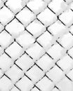 Snow piled on the wire of a diamond mesh black fence