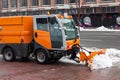 Snow plough cleaning pavements and streets which are covered in snow and mud during heavy snowfall.
