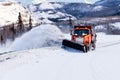Snow plough clearing road in winter storm blizzard