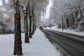 Snow plow is sprincling salt or de-icing chemicals on pavement in city