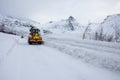 Snow plow truck clearing icy road after winter snowstorm blizzard for vehicle access Snow blower clears snow-covered streets Royalty Free Stock Photo