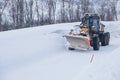 Snow plow truck clearing icy road after winter snowstorm blizzard for vehicle access Snow blower clears snow-covered streets