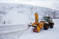 Snow plow truck clearing icy road after winter snowstorm blizzard for vehicle access Snow blower clears snow-covered streets