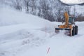 Snow plow truck clearing icy road after winter snowstorm blizzard for vehicle access Snow blower clears snow-covered streets Royalty Free Stock Photo