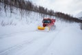 Snow plow truck clearing icy road after winter snowstorm blizzard for vehicle access Snow blower clears snow-covered streets Royalty Free Stock Photo