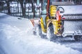 Snow plow truck clearing road after winter snowstorm blizzard for car. Royalty Free Stock Photo