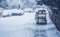 Snow plow truck clearing road after winter snowstorm blizzard for car. Royalty Free Stock Photo