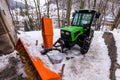 Snow plow truck in winter on path. Green color and modern design.