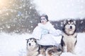 Snow-queen. Fairy tale girl with Huskies or Malamute. Royalty Free Stock Photo