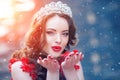 Snow Queen in red. Winter woman in crown in a red dress and red