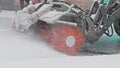 Snow removal car with rotating brush cleans the street of St.Petesburg during a snowfall