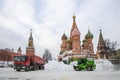 Snow removal in the center of Moscow. A front-end loader loads snow into a large semi-trailer next to St. Basil's