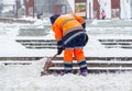 Snow removal in the city. A worker clears snow with a shovel after a snowfall on the steps