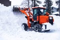 Snow removal excavator tractor cleaning on winter road covered with snow Royalty Free Stock Photo