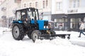 Snow removal machine cleaning the street from snow. Snowplow truck removing snow on the street after blizzard Royalty Free Stock Photo