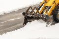 Snow removal. Wheel loader machine or vehicle removing snow from the roads Royalty Free Stock Photo