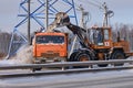 Snow removal in winter from roads with an excavator and a truck KAMAZ vehicle - Moscow, Russia, January 17, 2021 Royalty Free Stock Photo
